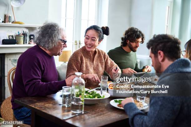 extended family having meal together - happy family eating photos et images de collection