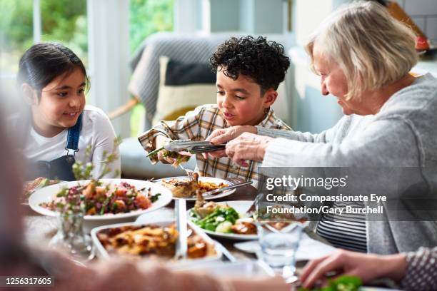 extended family having meal together - british granny stock-fotos und bilder