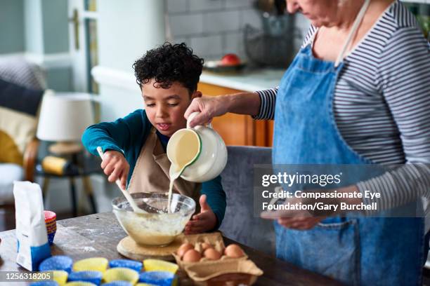 grandmother and grandson baking cupcakes - milk family stockfoto's en -beelden