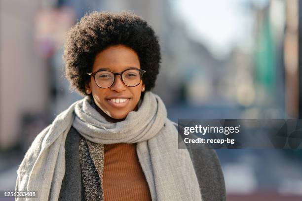 waist up portrait of young black woman smiling for camera - scarf stock pictures, royalty-free photos & images