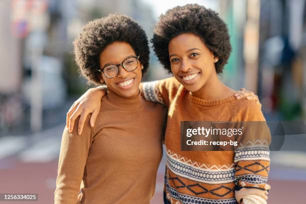 portrait of black twin sisters in street - identical twin stock pictures, royalty-free photos & images