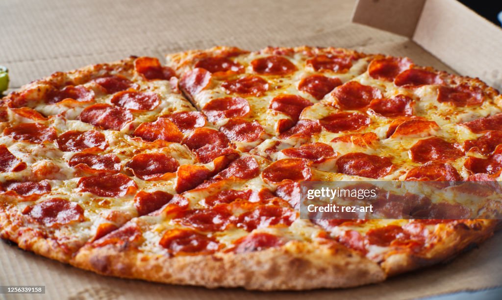 Large american style pepperoni and cheese pizza in cardboard delivery box