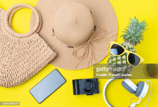 women's accessories traveler. colorful summer female fashion outfit. straw hat. bamboo bag. pineapple hipster in sunglasses over yellow background. summer fashion or holiday travel concept - beach flat lay stock pictures, royalty-free photos & images