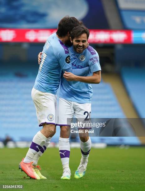 David Silva of Manchester City celebrates with teammate Bernardo Silva after scoring his side's first goal during the Premier League match between...