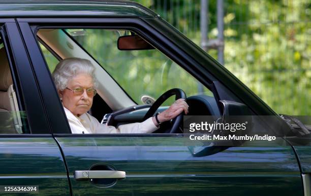 Queen Elizabeth II seen driving her Range Rover car as she watches the International Carriage Driving Grand Prix event on day 4 of the Royal Windsor...