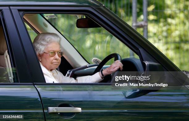 Queen Elizabeth II seen driving her Range Rover car as she watches the International Carriage Driving Grand Prix event on day 4 of the Royal Windsor...