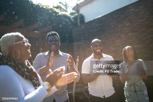 group of friends / family having fun in the garden - black family reunion stock pictures, royalty-free photos & images
