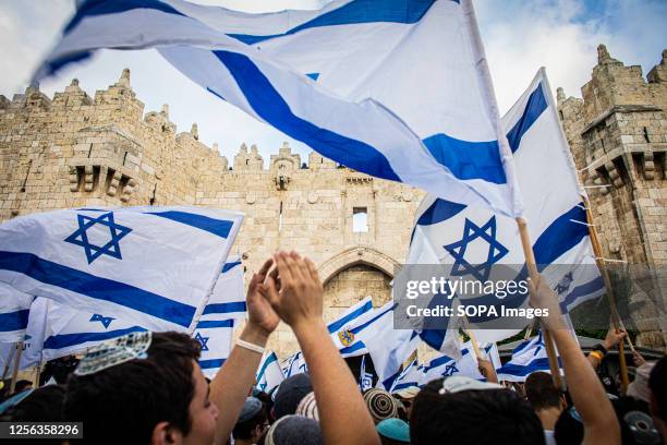 Israeli youths wave Israeli flags outside Damascus gate In Jerusalem during the flag march. Tens of thousands of young religious-Zionist men and...