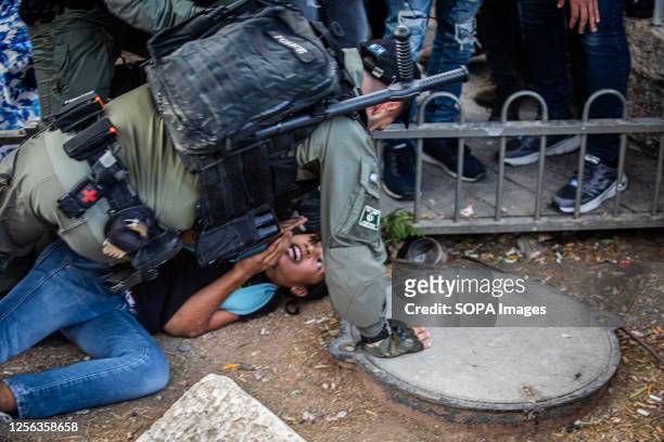 An Israeli border police officer detains a right wing youth outside Damascus gate In Jerusalem during the flag march. Tens of thousands of young...