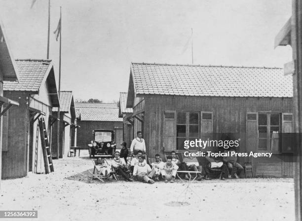 Athletes sitting in front of a cabin in the Olympic Village at the 1924 Summer Olympics in Paris, France, 1924. The 1924 Games were the first Games...