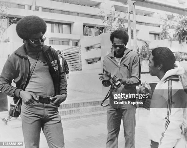 American sprinter John Smith, American sprinter Vince Matthews, and the Swiss team's doctor - and former American athlete - Dave James in...