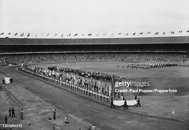 The closing ceremony of the 1956 Summer Olympics showing the Olympic flag being carried to the rostrum where it will be handed to Lord Mayor of...
