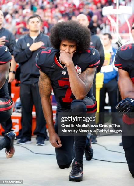 San Francisco 49ers quarterback Colin Kaepernick covers is mouth as he kneels during the national anthem before their NFL game against Arizona...