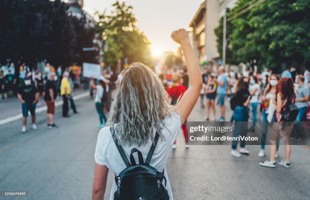 年輕女子抗議者舉起拳頭。