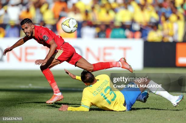 Wydad's Moroccan forward Mohammed Ounajem is tackled by Sundowns' Moroccan defender Abdelmounaim Boutouil during the CAF Champions League 2nd leg...