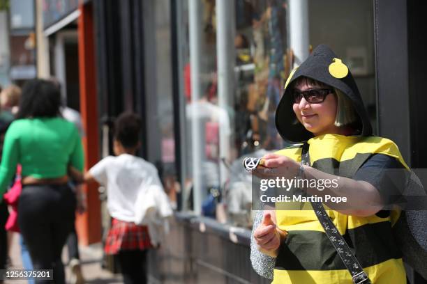 Protester gives out Extinction Rebellion stickers as they march through the city centre on May 20, 2023 in Bury St Edmunds, United Kingdom. On World...