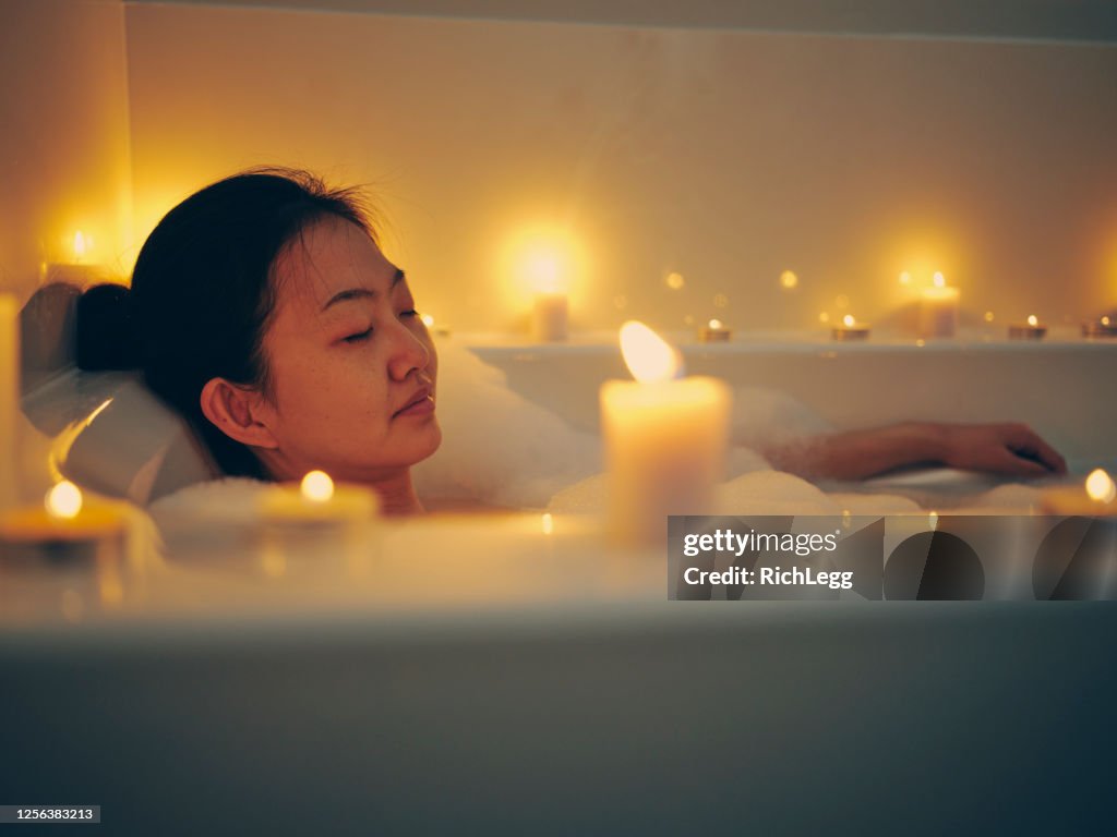 Japanische Frau nimmt ein Candlelight Bad