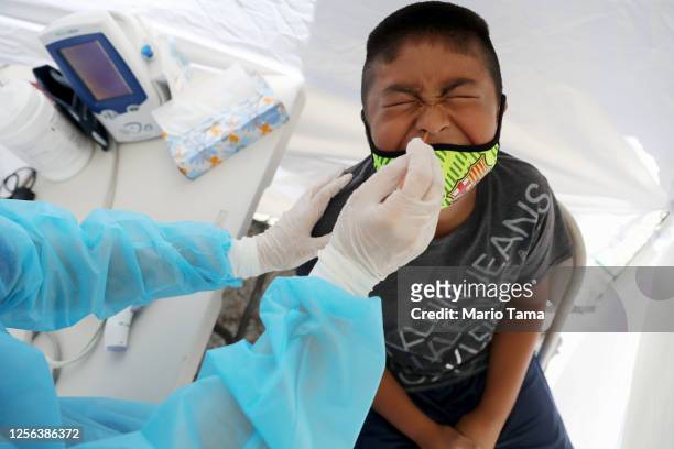 Boy receives a free COVID-19 test at a St. John’s Well Child & Family Center mobile clinic set up outside Walker Temple AME Church in South Los...
