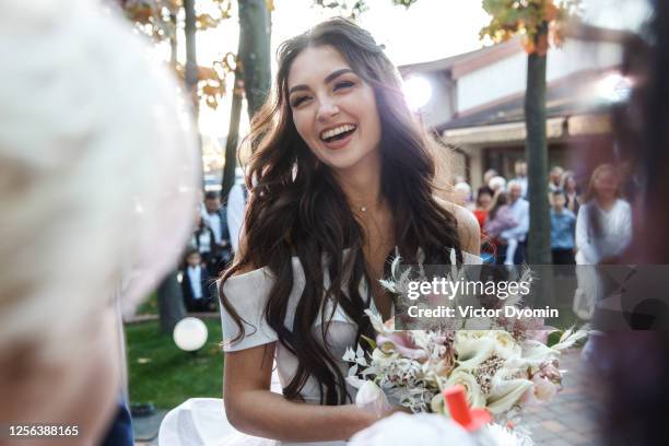 outdoor portrait of the smiling bride among guests - bride fotografías e imágenes de stock