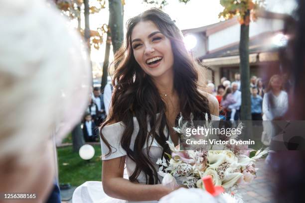 outdoor portrait of the smiling bride among guests - sposa foto e immagini stock