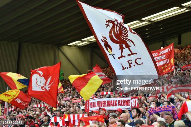 Fans wave flags ahead of the English Premier League football match between Liverpool and Aston Villa at Anfield in Liverpool, north west England on...