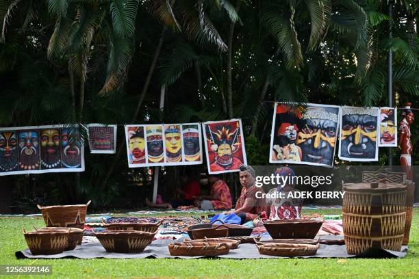 Papua New Guinean women sell souvenirs at a craft market in Port Moresby on May 20, 2023.