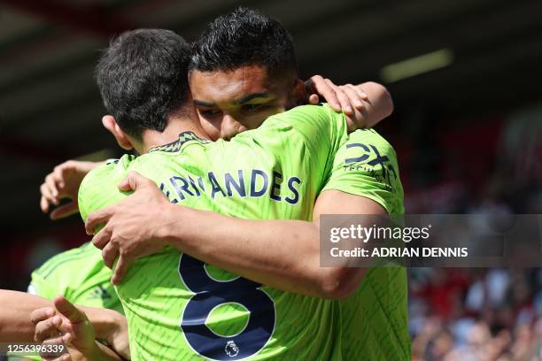 Manchester United's Brazilian midfielder Casemiro celebrates with Manchester United's Portuguese midfielder Bruno Fernandes after scoring the opening...