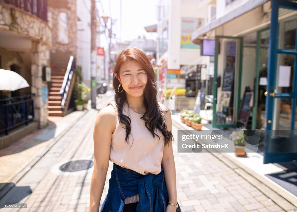 Portrait of young woman standing on shopping street