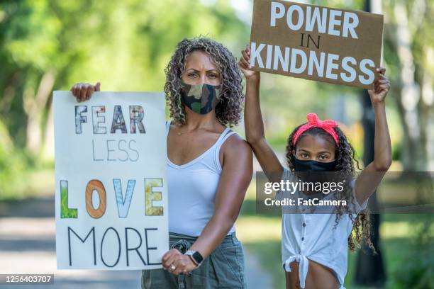 afrikaanse amerikaanse moeder en dochter die protesttekens houden - sociale rechtvaardigheid stockfoto's en -beelden