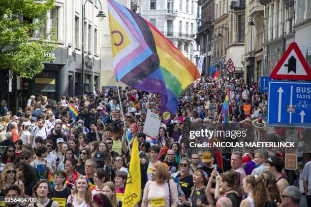 People wave Rainbow flags as they parade as part of 'Brussels Pride', a Lesbian, Gay, Bisexual and Transgender celebration, in Brussels on May 20,...