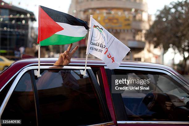 Man gestures between Palestinian flags on a car September 19, 2011 in Ramallah, West Bank. Palestinian President Mahmoud Abbas is reportedly told...