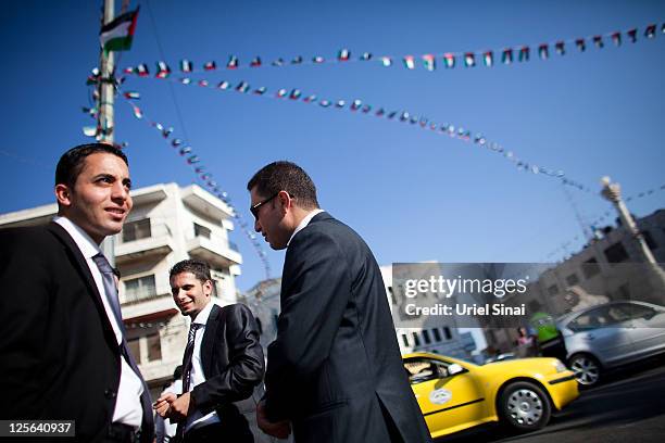 Palestinians stand beneath flags decorating a main a round-about September 19, 2011 in Ramallah, West Bank. Palestinian President Mahmoud Abbas is...