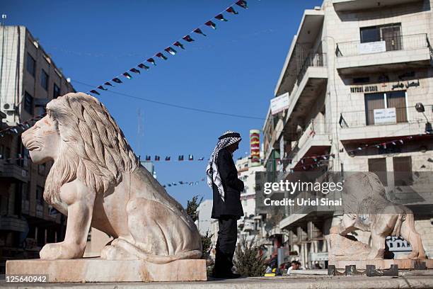 Palestinians man prays below flags decorating a main a round-about September 19, 2011 in Ramallah, West Bank. Palestinian President Mahmoud Abbas is...