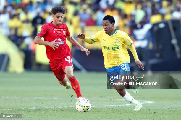 Sundowns' South African midfielder Sphelele Mkhulise runs with the ball under pressure from Wydad's Moroccan forward Abdellah Haimoud during the CAF...