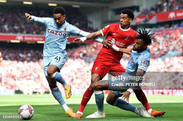 Liverpool's Dutch striker Cody Gakpo vies with Aston Villa's English midfielder Jacob Ramsey and Aston Villa's English defender Tyrone Mings during...