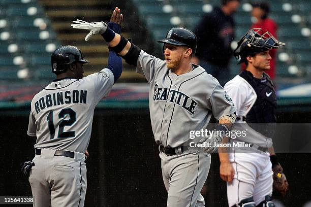 Trayvon Robinson celebrates with Mike Carp of the Seattle Mariners after Carp hit a grand slam during the third inning against the Cleveland Indians...