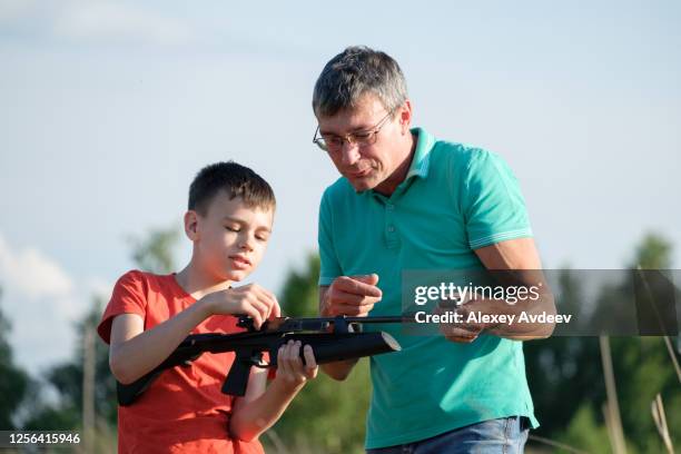 father and son rifle lessons - air rifle shooting stock pictures, royalty-free photos & images