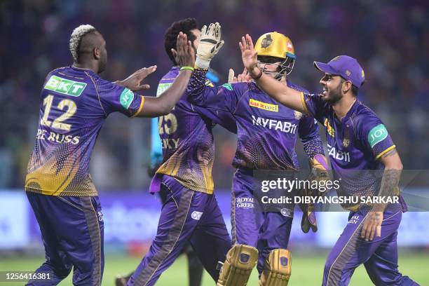 Kolkata Knight Riders' Andre Russell celebrates with teammates after taking the wicket of Lucknow Super Giants' Quinton de Kock during the Indian...