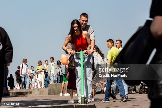Couple rides a scooter and enjoys warm weather on Saturday afternoon on the famous promenade by the banks of Dnipro River in central Kyiv, the...