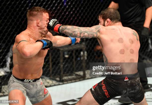 Jimmie Rivera punches Cody Stamann in their featherweight fight during the UFC Fight Night event inside Flash Forum on UFC Fight Island on July 16,...