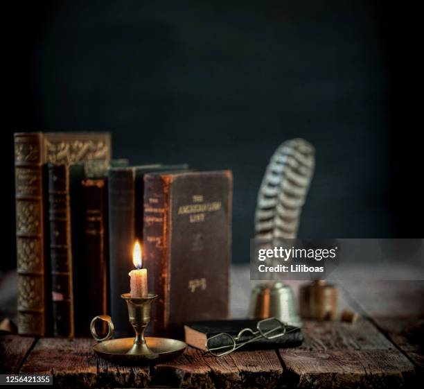 vintage books on an old wood table - candle holder stock pictures, royalty-free photos & images