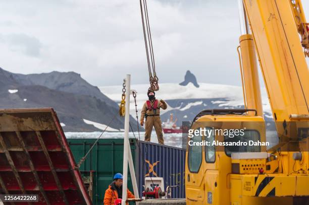 Brazilian Navy officer getting ready to attach crane cables to the container, on January 07, 2020 in King George Island, Antarctica.