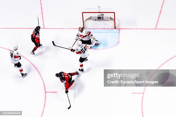 Michael Carcone of Canada scores the second goal for Team Canada against goalkeeper Leonardo Genoni of Switzerland during the 2023 IIHF Ice Hockey...