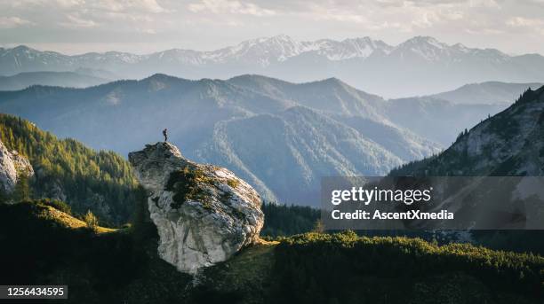 wanderer entspannt sich auf bergrücken bei sonnenaufgang - mountains landscape stock-fotos und bilder