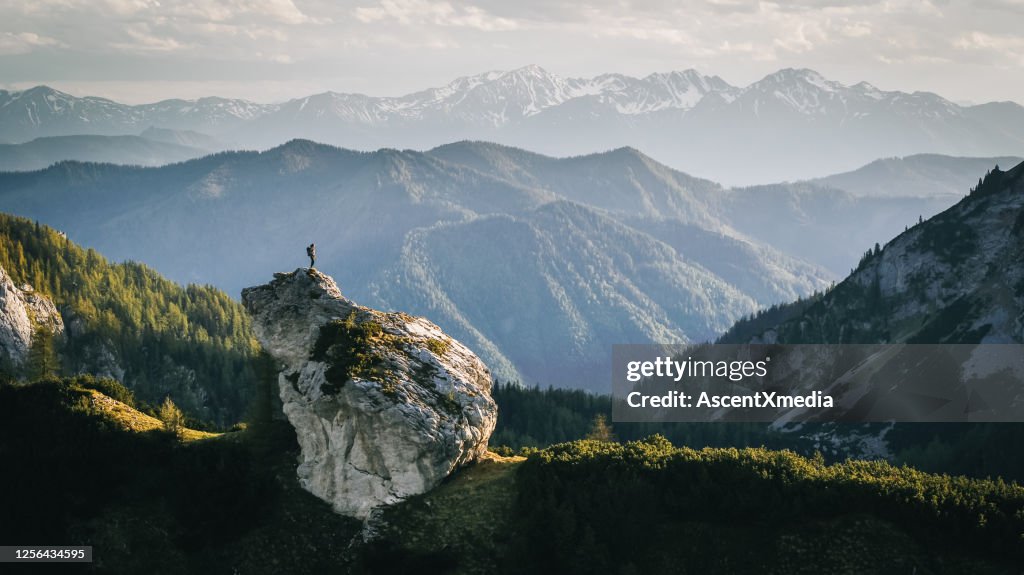 Escursionista si rilassa sulla cresta di montagna all'alba