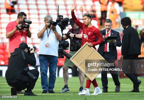 Liverpool's Brazilian striker Roberto Firmino applauds the fans following the English Premier League football match between Liverpool and Aston Villa...