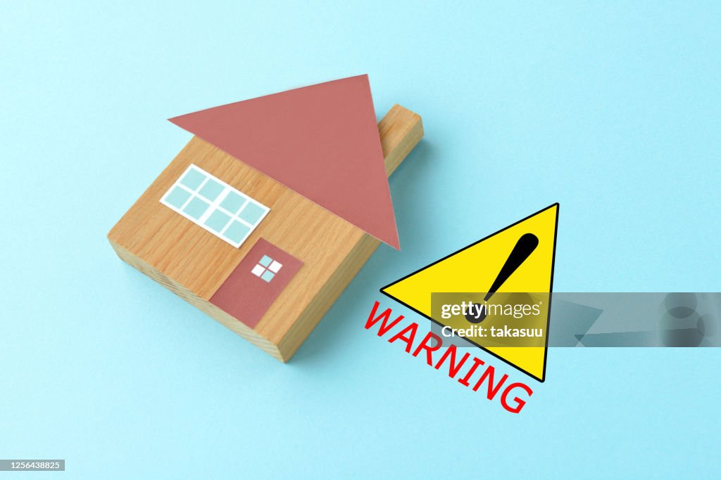 Warning sign and house object on light blue background