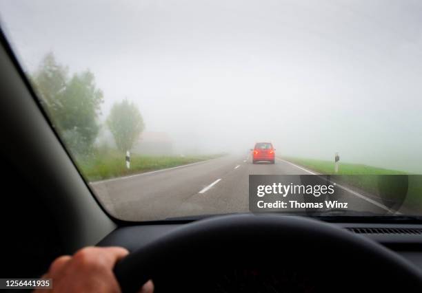 driving on a foggy country road - penumbra fotografías e imágenes de stock