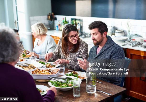 extended family having meal together - dîner photos et images de collection