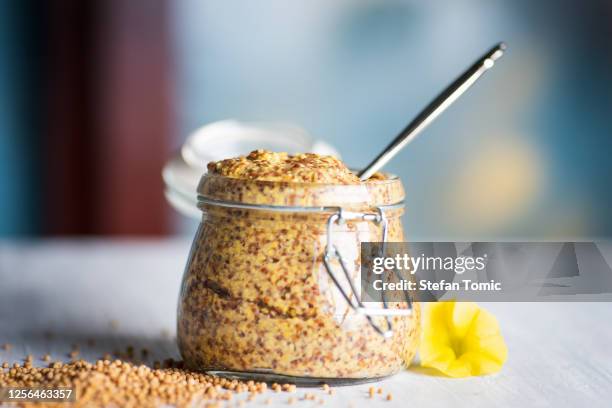 moutarde de grains entiers dans un bocal sur une table - moutarde assaisonnements et vinaigrettes photos et images de collection